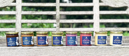 Infused Creamed Honey jars lined up on a bench